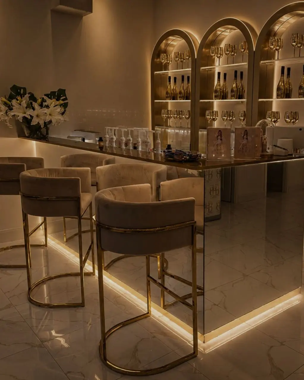 Elegante Beauty-Bar mit goldenen Bögen und warmer Beleuchtung.